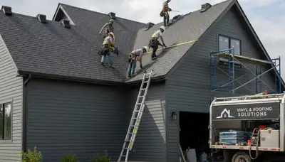 Roof installation crew working on vinyl-sided home in Shreveport, LA